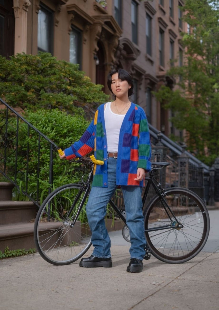 nonbinary trans man standing outside with a bicycle