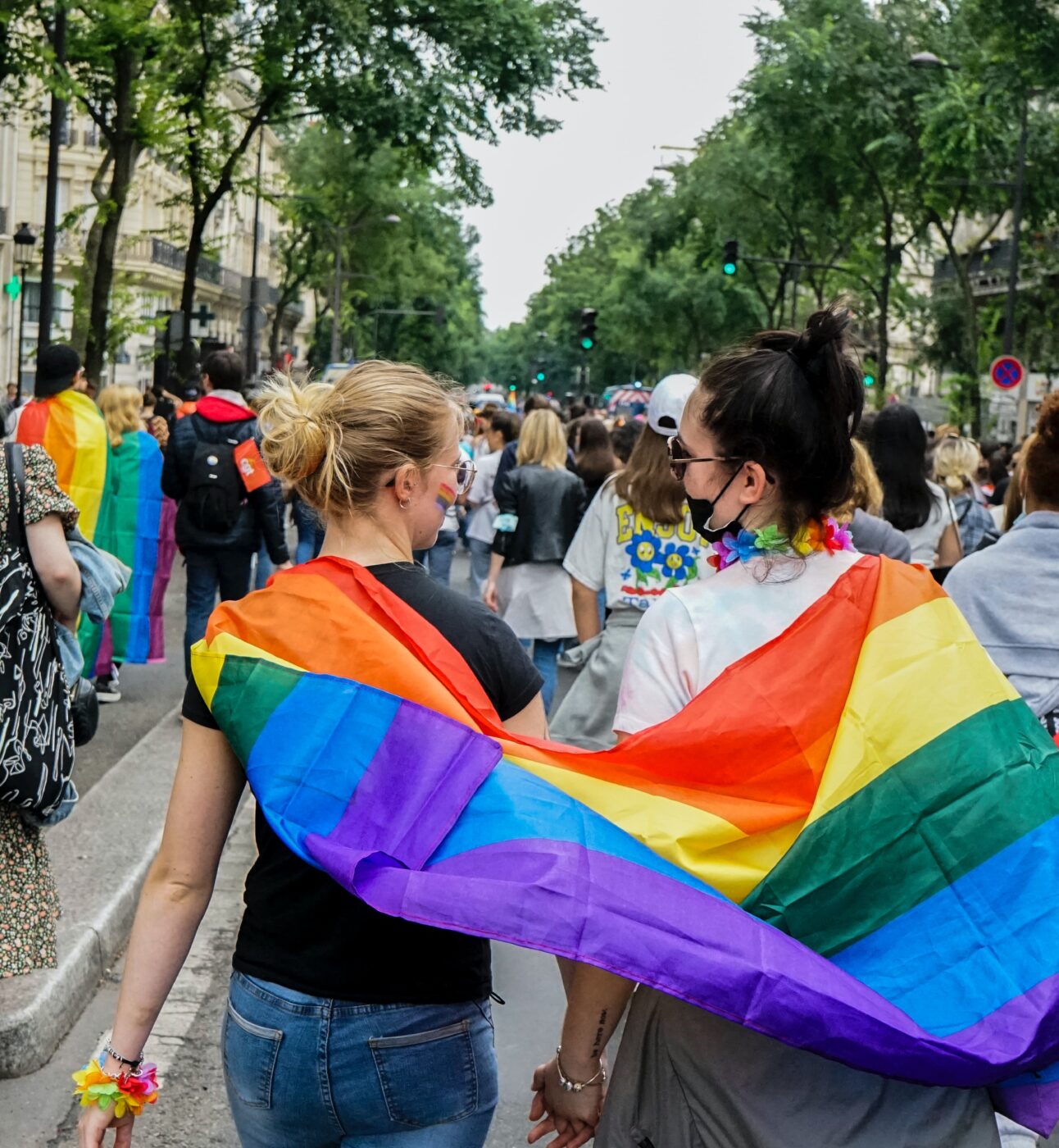 Two people at pride with a flag.