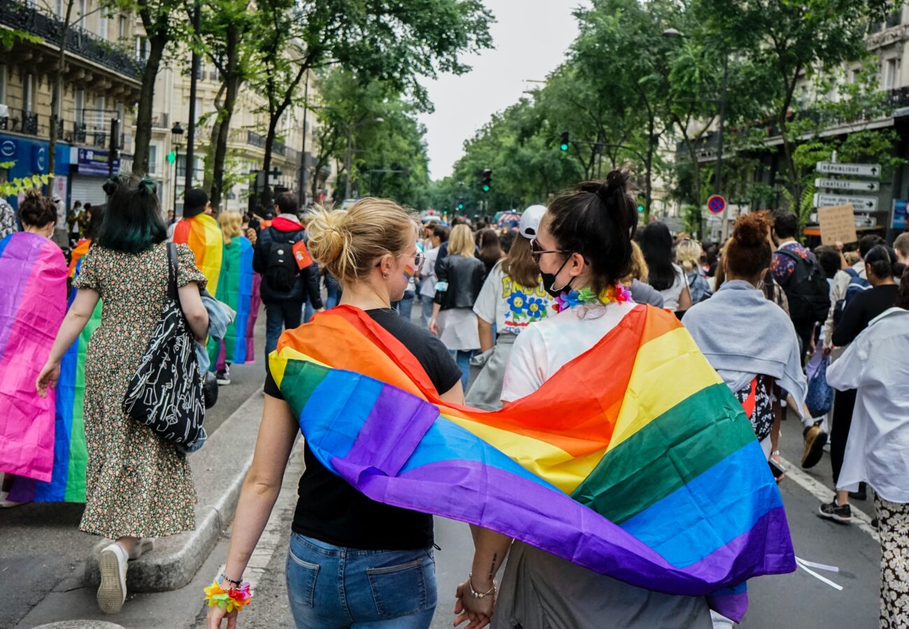 Two people at pride with a flag.