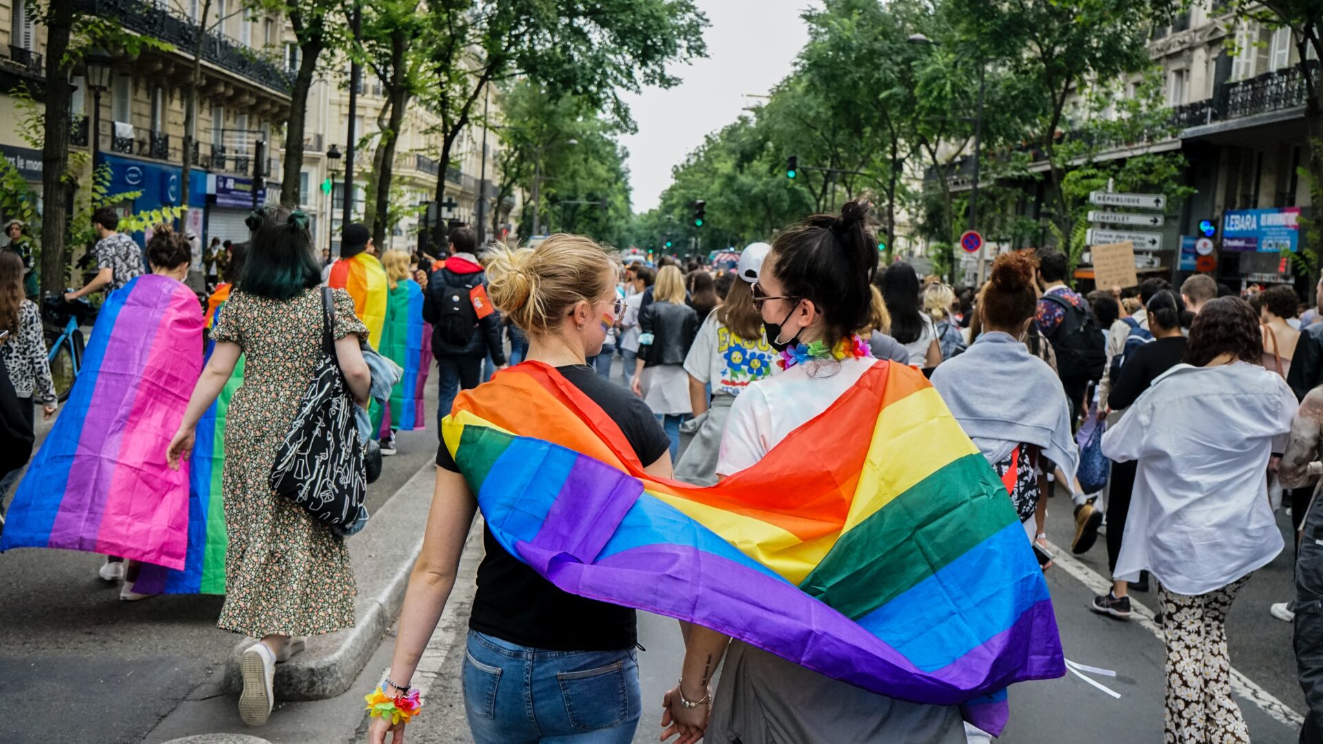 Two people at pride with a flag.