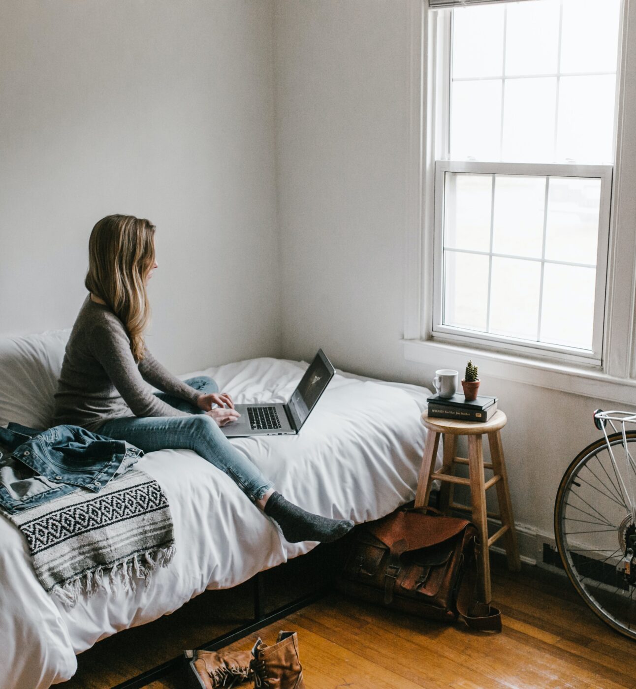 A person sat in bed doing work on their laptop