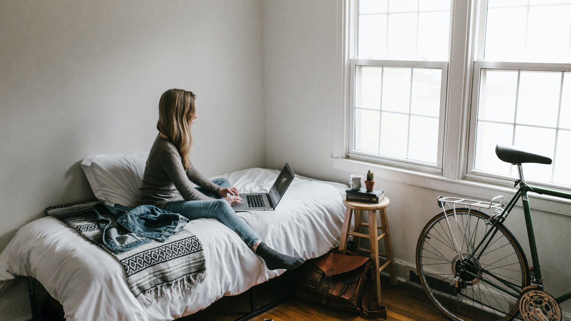 A person sat in bed doing work on their laptop