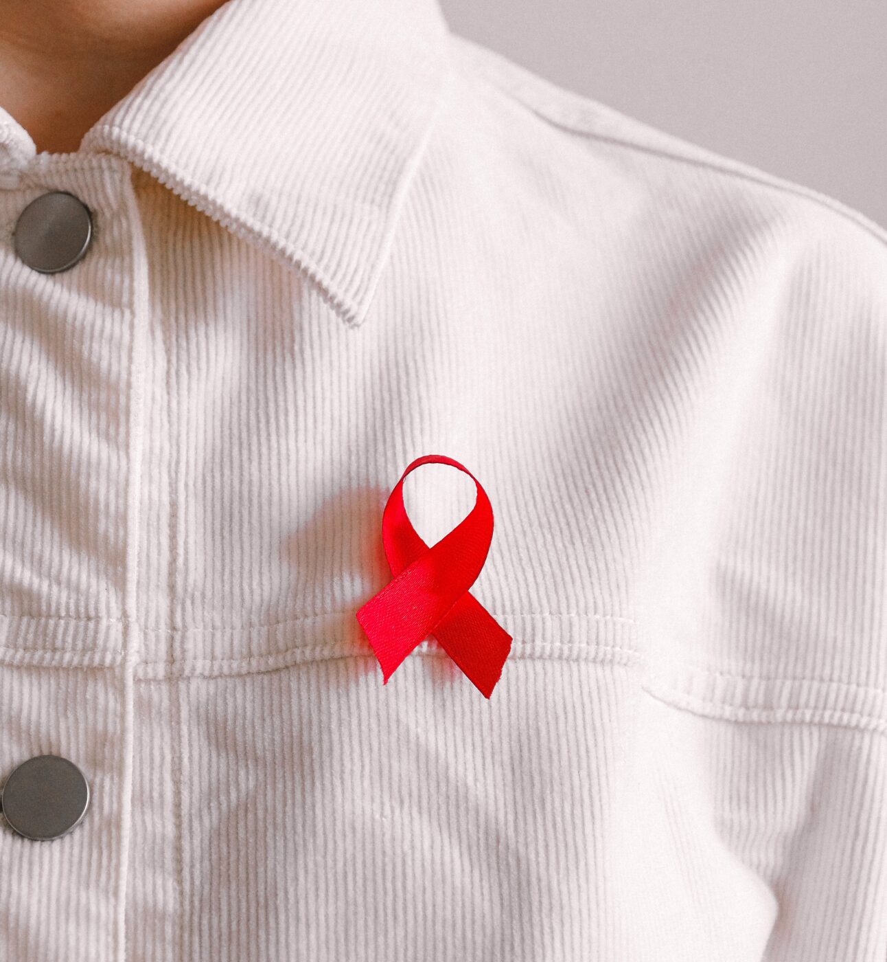 A person wearing a HIV awareness ribbon.