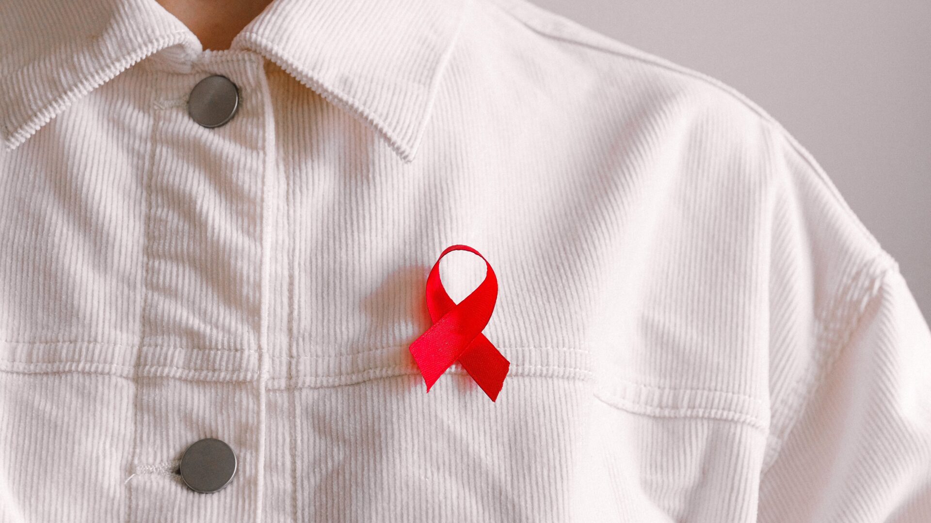 A person wearing a HIV awareness ribbon.
