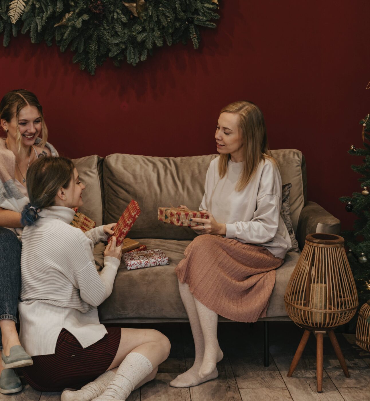 three friends sitting by a Christmas tree