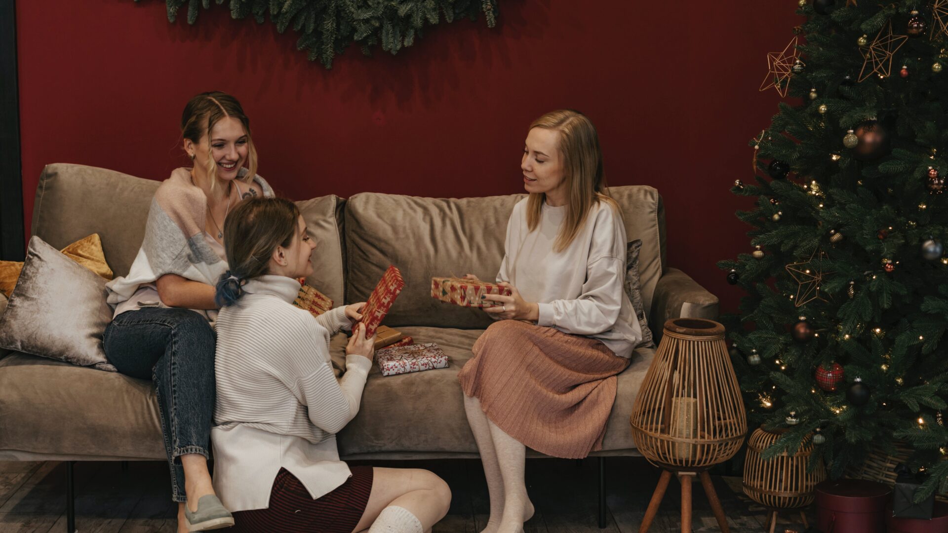 three friends sitting by a Christmas tree