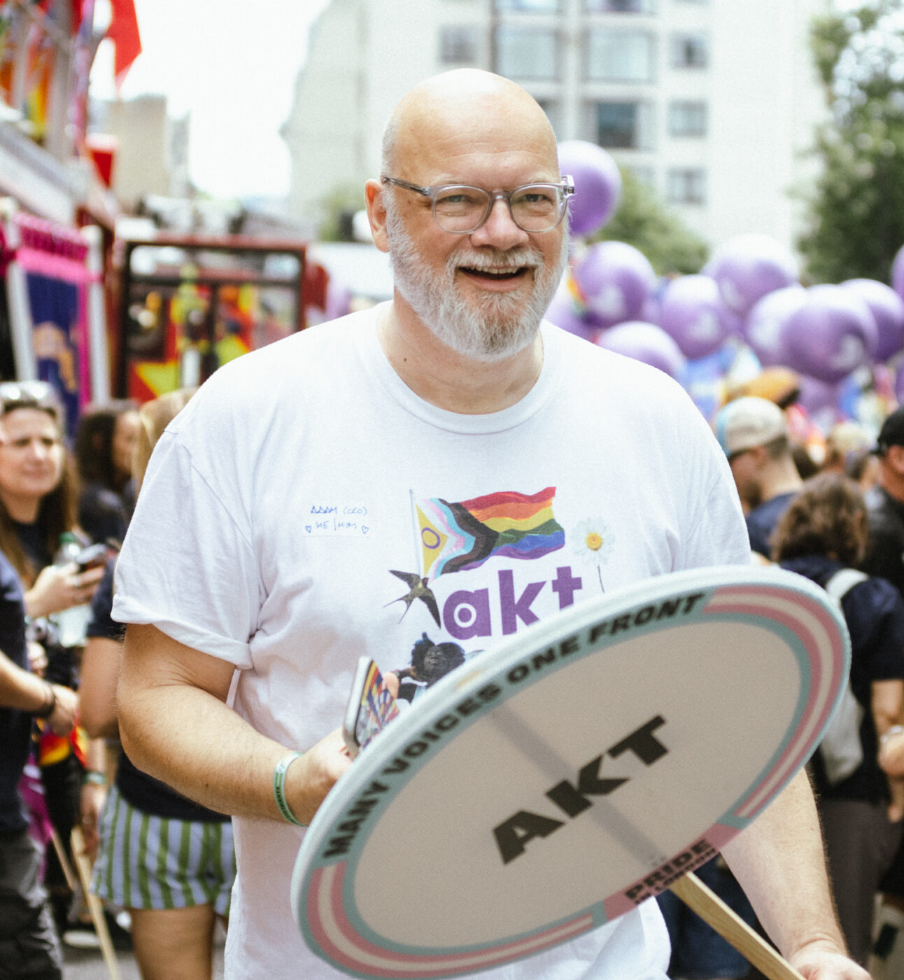 A photo of akt's CEO Adam Pemberton Wickham at Pride in London 2026, wearing an akt t-shirt and holding an akt placard.